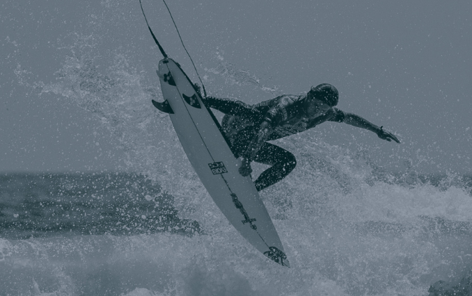Surfer launching an aerial off a wave